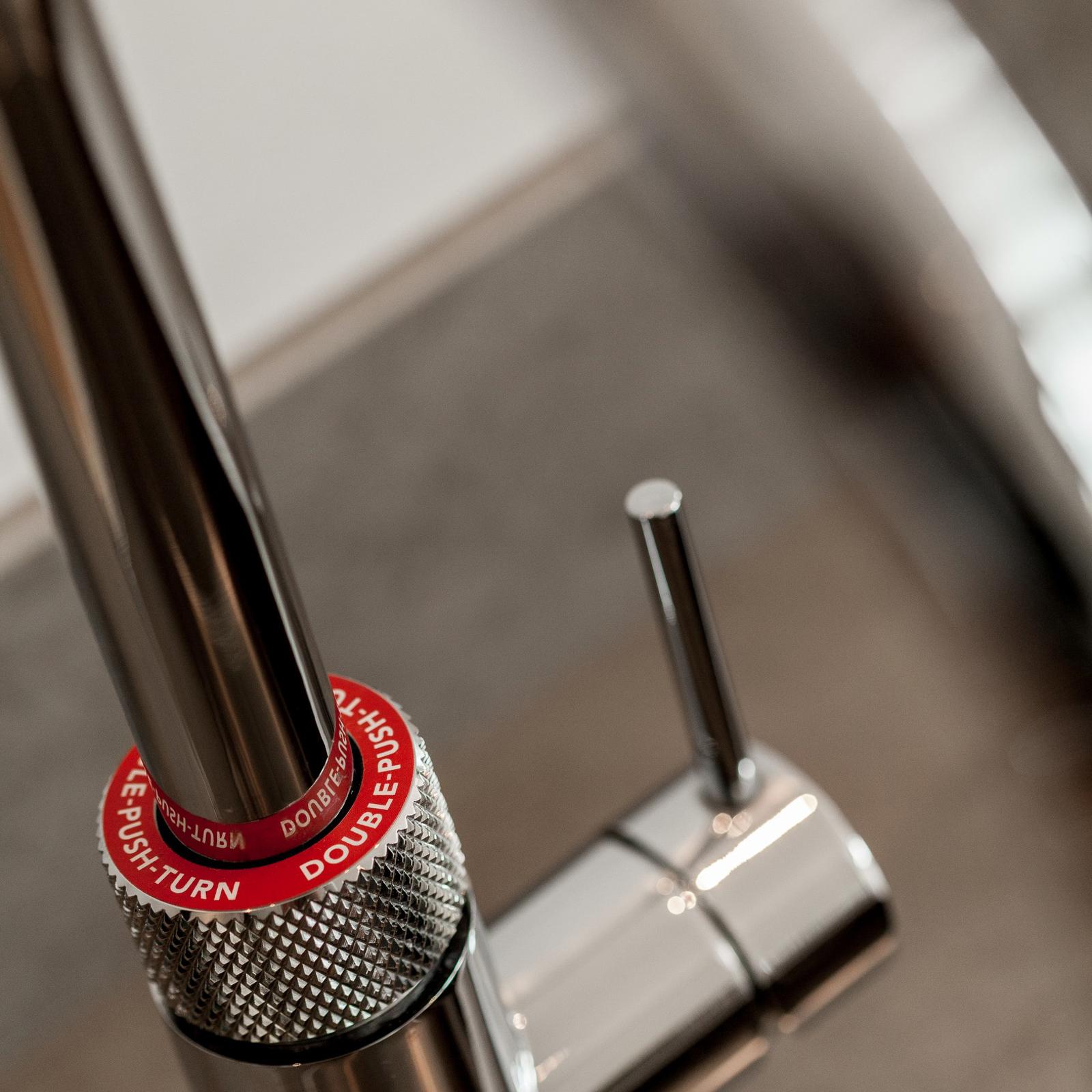 Verchroomde keukenkraan met kokendwaterfunctie en rode push-turn bedieningsring