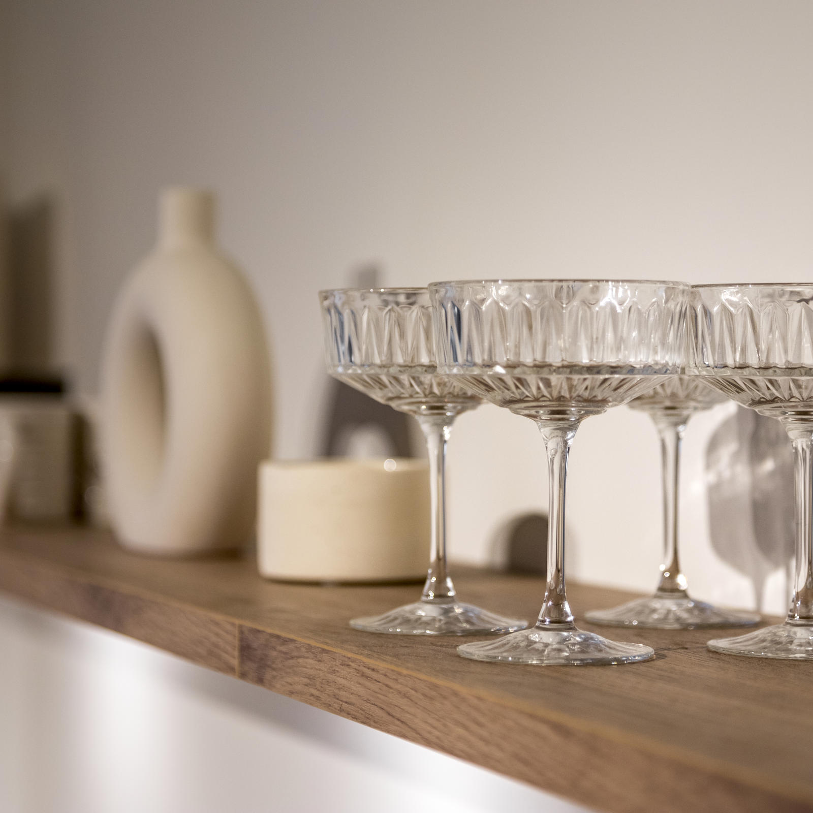 Kristallen coupeglazen en decoratie op een houten wandplank