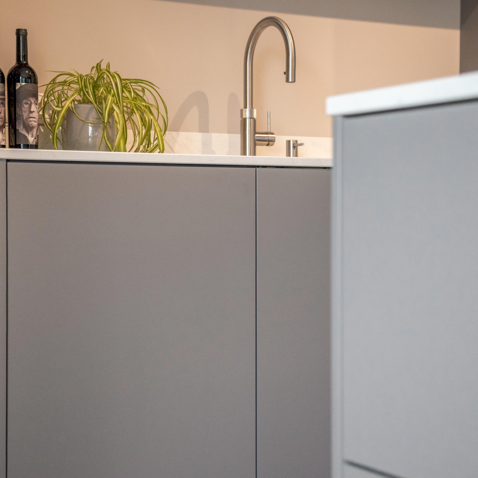 Taupe greeploze onderkasten met keramisch werkblad en RVS kraan